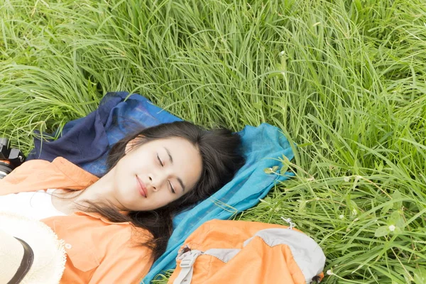 Jeune femme couchée sur l'herbe verte profiter de la musique avec casque — Photo