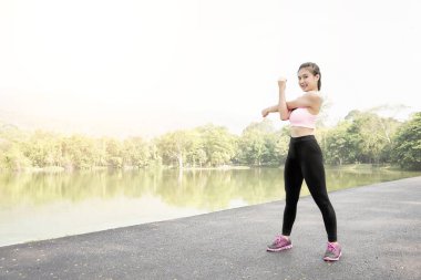 Isınma ve germe bahçede yolda genç spor kadın