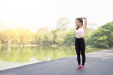 Isınma ve germe bahçede yolda genç spor kadın