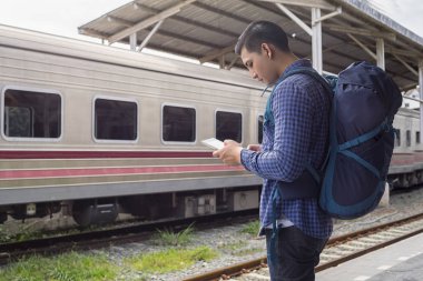 Sırt çantalı bir gezgin tablet bilgisayar ve seyahat konsepti kullanarak konumu arıyor