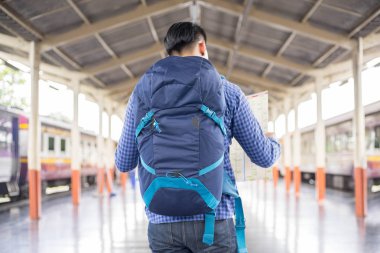 Sırt çantalı bir gezgin tren istasyonunda arama yapıyor. Seyahat konsepti.