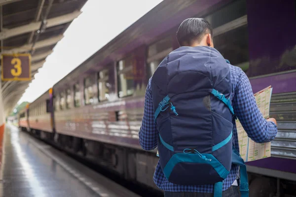 Hombre viajero con mochilero buscar ubicación en trainsta —  Fotos de Stock