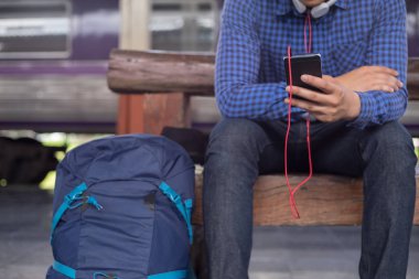 Sırt çantalı bir gezgin telefon ve seyahat konseptinde yer arıyor.