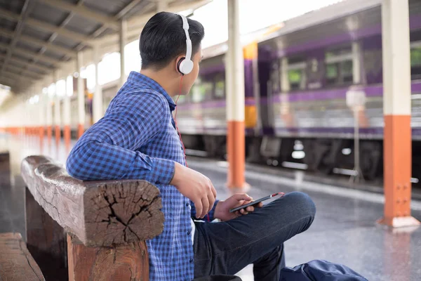 Adam Gezgin ile backpacker trainstation, müzik dinlemek — Stok fotoğraf