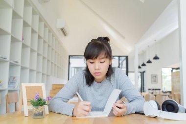 Üniversite öğrencisi not defterine, eğitime ve öğrenme konseptine düşünüyor ve yazıyor