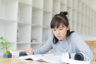 Bayan üniversite öğrencisi kütüphane, eğitim ve öğrenim konseptinde kitap okuyor