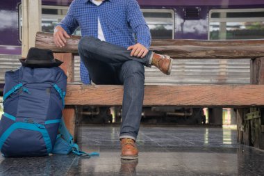 Tren istasyonunda sırt çantalı bir gezgin, seyahat konsepti.