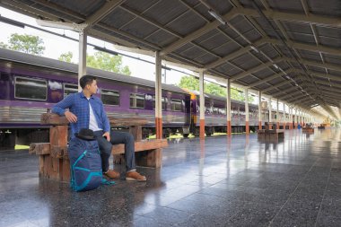 Tren istasyonunda sırt çantalı bir gezgin, seyahat konsepti.