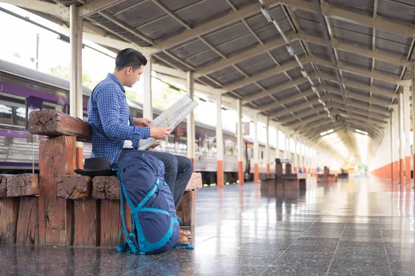 Sırt çantalı gezgin tren istasyonundaki haritayı kullanarak konumu arıyor, seyahat kavramı