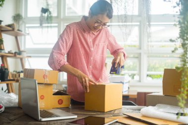 Mutlu kadın paketleme ürünü ev, online iş konsepti, iş sahibi konsepti