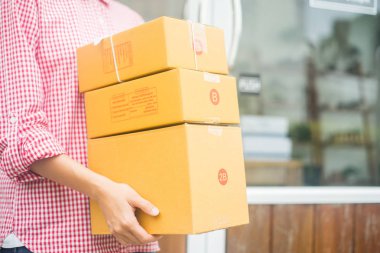 Teslimat için paket taşıyan mutlu kadın, iş sahibi konsepti.