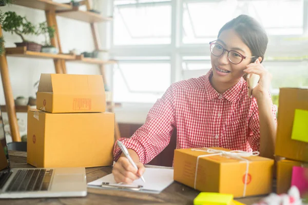 Mutlu kadın evde akıllı telefon, online iş konsepti, iş sahibi konsepti ile çevrimiçi sipariş kontrol