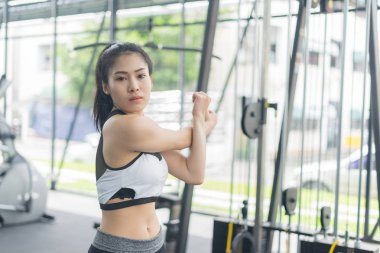 Spor salonunda ısınan ve esneyen spor kadını.