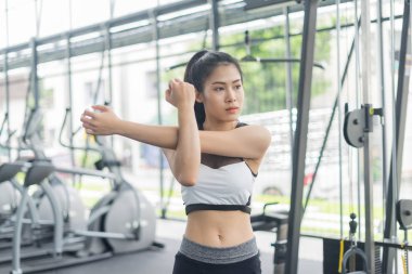 Spor salonunda ısınan ve esneyen spor kadını.