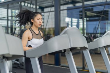 Spor salonunda spor makinesiyle koşan spor kadını, fitness konsepti, spor konsepti