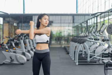Spor salonunda ısınan ve esneyen spor kadını.