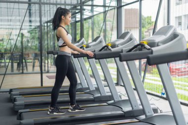 Spor salonunda spor makinesiyle koşan spor kadını, fitness konsepti, spor konsepti