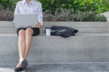 Modern iş kadını dışarıda dizüstü bilgisayarla çalışıyor, iş konsepti