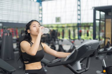 Spor ve spor konsepti egzersizlerinden sonra içme suyu eğitimi alan fitness kadını.