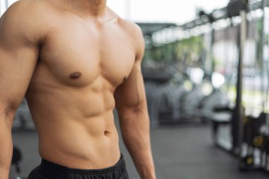 Spor salonunda kaslı vücut gösteren fitness adamı, fitness konsepti, spor konsepti