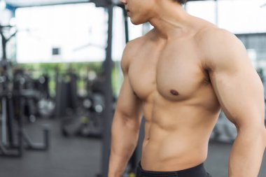 Spor salonunda kaslı vücut gösteren fitness adamı, fitness konsepti, spor konsepti