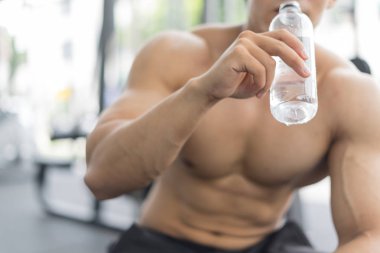 Spor ve spor konsepti egzersizlerinden sonra içme suyu eğitimi alan fitness adamı.