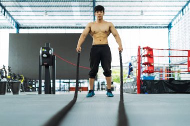 Spor salonundaki antrenman halatı, spor konsepti, spor konsepti ve spor ipiyle egzersizleri gösteriyor.