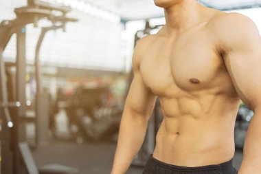 Spor salonunda kaslı vücut gösteren fitness adamı, fitness konsepti, spor konsepti