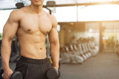 Spor salonunda kaslı vücut gösteren fitness adamı, fitness konsepti, spor konsepti