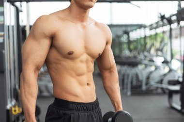 Spor salonunda kaslı vücut gösteren fitness adamı, fitness konsepti, spor konsepti