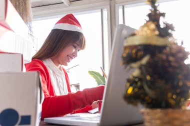 Noel Baba şapkası giyen bir kadın. Çevrimiçi iş, iş sahibi kavramı