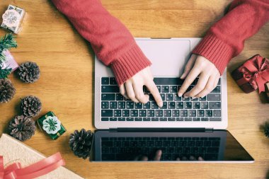 Noel Baba şapkası giyen bir kadın çevrimiçi işleri kontrol ediyor, iş sahibi kavramı