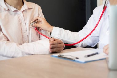 Beyaz üniformalı doktor önlüğüyle görüşmeyi kapatın ve hastaya danışmanlık yaparken başvuru formunu doldurun, tıbbi konsept