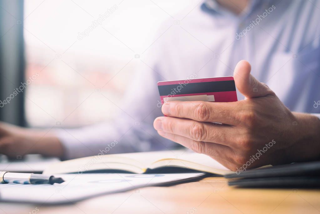 man holding credit card and using laptop and smartphone shopping website online, shopping concept