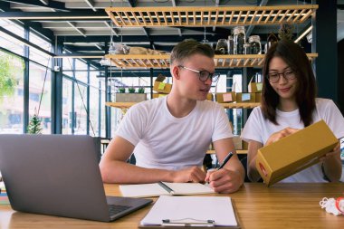 Bilgisayarlı mutlu insanlar hisse senedi ürünlerini kontrol etmek için çalışıyor. Evdeki internet ofisi, internet sektörü.