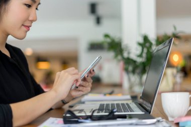 Dizüstü bilgisayar ve belgelerle çalışan genç iş kadını, iş konsepti