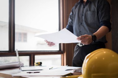 Genç mühendisler ofisteki taslak modern projeye, mühendis konseptine bakıyorlar.