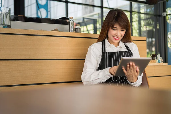 business owner using tablet pc in coffee shop, owners business