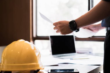 mühendisler plan üzerine bina işaret ve tasarım bina Proje çizim için dizüstü bilgisayar kullanarak ofis, inşaat konsepti. Mühendis kavramı