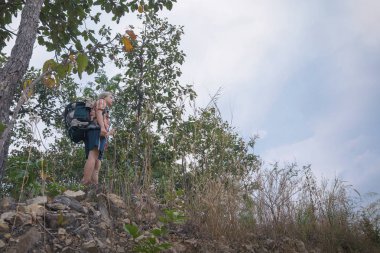 Genç yürüyüşçü sırt çantası, yürüyüş konsepti ve seyahat konseptiyle seyahat etmeyi sever.
