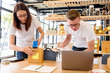 Bilgisayarlı mutlu insanlar hisse senedi ürünlerini kontrol etmek için çalışıyor. Evdeki internet ofisi, internet sektörü.