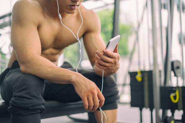 Fitness man relaxing seat listening to music after he exercises, fitness concept, sport concept
