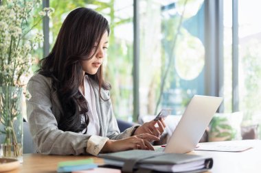 Kadın kredi kartı tutuyor ve laptop ve akıllı telefon alışveriş sitesi kullanıyor, alışveriş kavramı