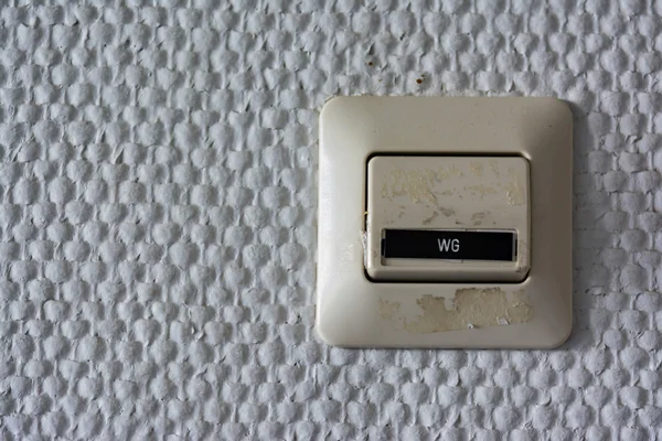 WG Wohngemeinschaft etiqueta interruptor pared plástico detalle textura arquitectónica — Foto de Stock