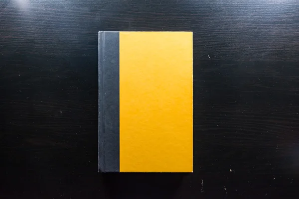 Papel de capa dura em branco amarelo Páginas do livro da frente Black Desk — Fotografia de Stock