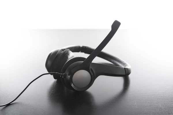 Гарнітура навушники розміщені Ергономічний чорний пластиковий сучасний яскравий робочий стіл — стокове фото