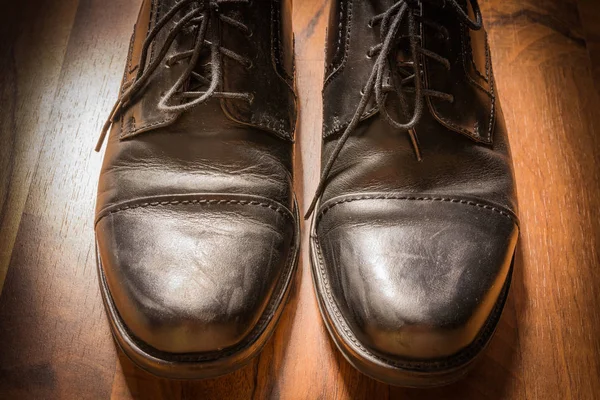 Zapatos de vestir de cuero negro usado piso de madera Sunlight Spotlight S — Foto de Stock