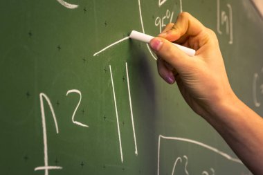 Female Hand Writing on Green Chalkboard  Math Number Pi