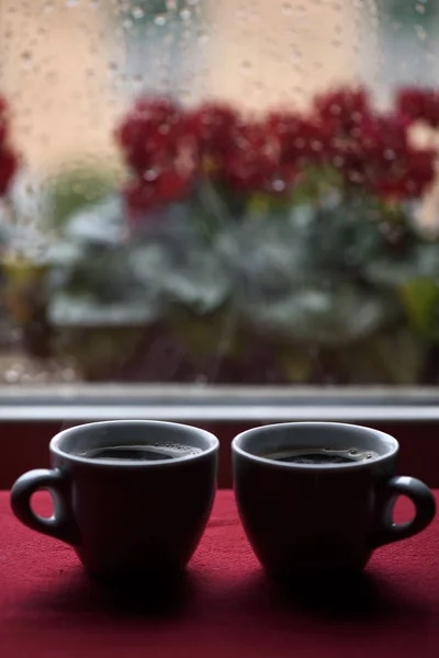 Tassen heißen Kaffee vor dem Fenster Regentropfen — Stockfoto