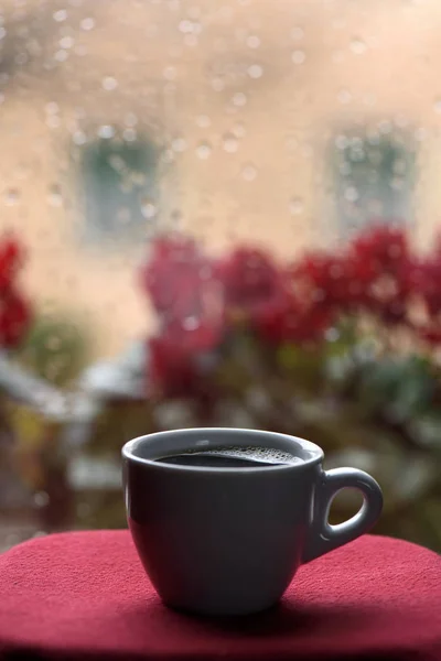 一杯热咖啡在窗前的雨滴 图库照片